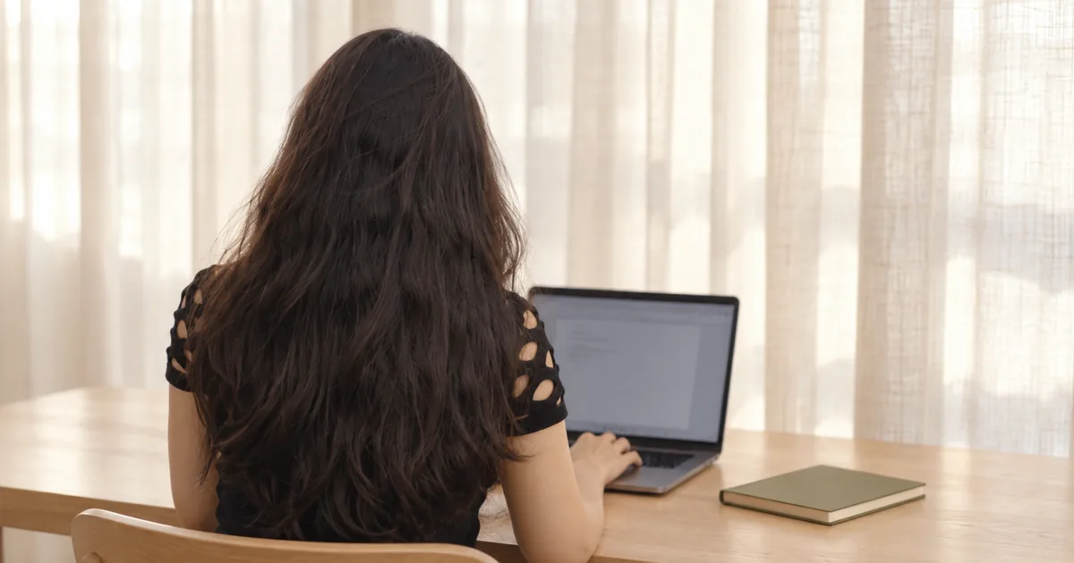 Representação de Juliana Santos em escritório minimalista, trabalhando com computador.